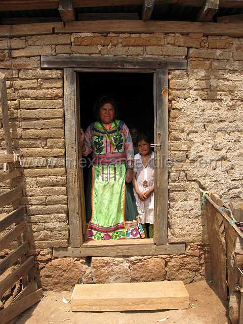 cora_pastor_05.JPG - Mother and daughter standing in the doorway of thier brick home.