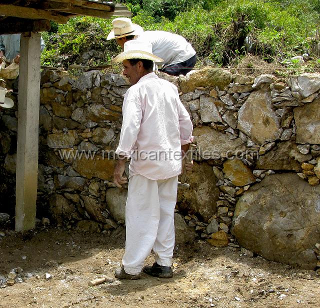 aguacatitla_mens.JPG - A few men still wear the "mantas" or white muslin suit. Here the mason is reconstructing a wall in the cemetery.