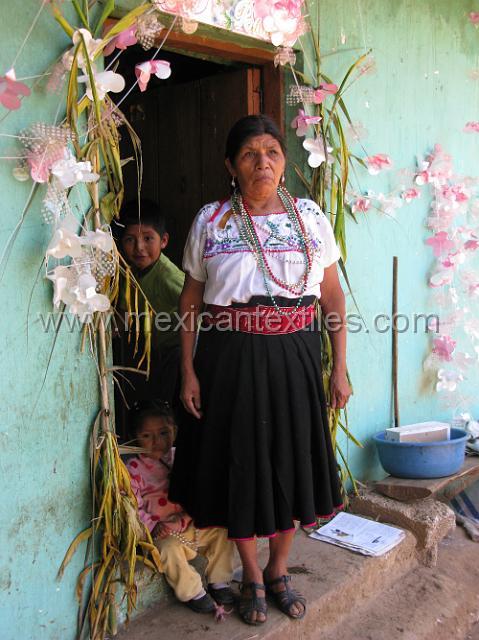 nahua_ixtolco_13.JPG - Florentina Cabrera Luna at the enterance to her home , she had just been part of a celebration and so the doorway way decorated.
